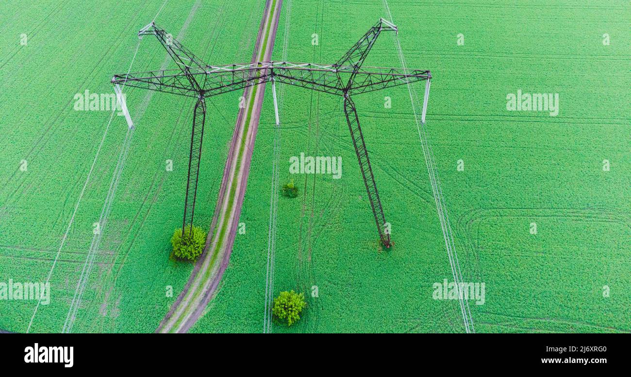 Top Electric high voltage post, High voltage energy transmission. Voltage post.High-voltage tower in green field background. Power distribution. Stock Photo