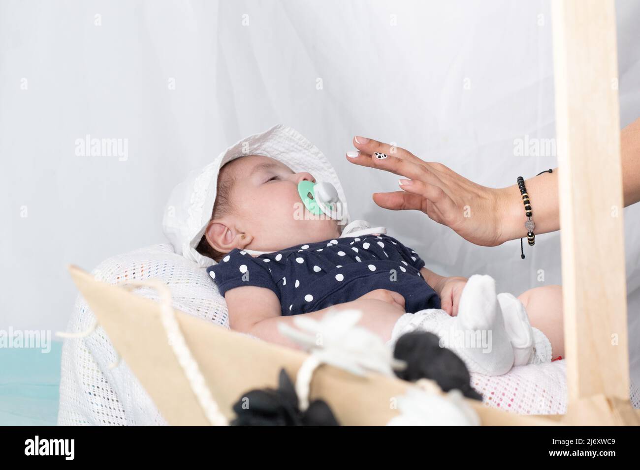 Hand of a mother putting a pacifier on her four month old baby to help