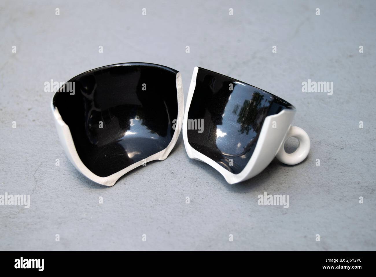 Cup of tea broken apart. Divorce and separation concept. Division of property in divorces, lawsuits. Broken relationships, division. Accidents and insurance. Stock Photo