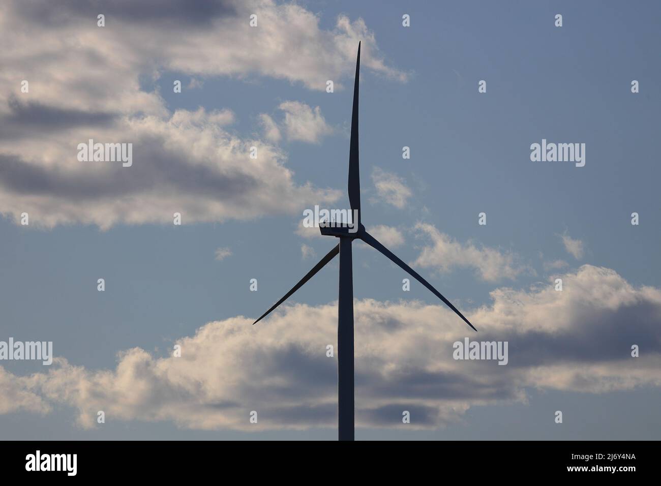Wind turbine with cloudy blue sky background Stock Photo - Alamy