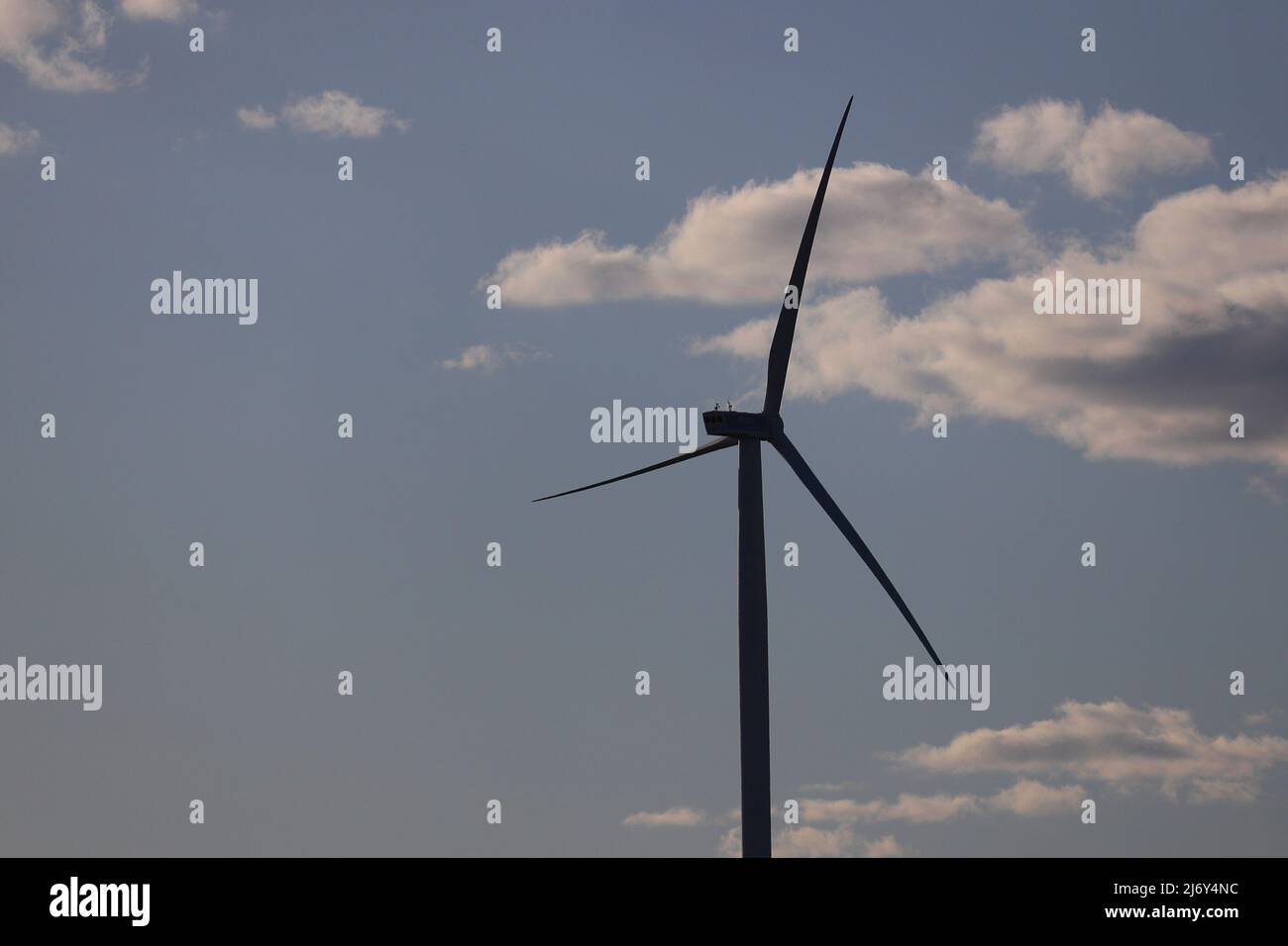 Wind turbine with cloudy blue sky background Stock Photo - Alamy