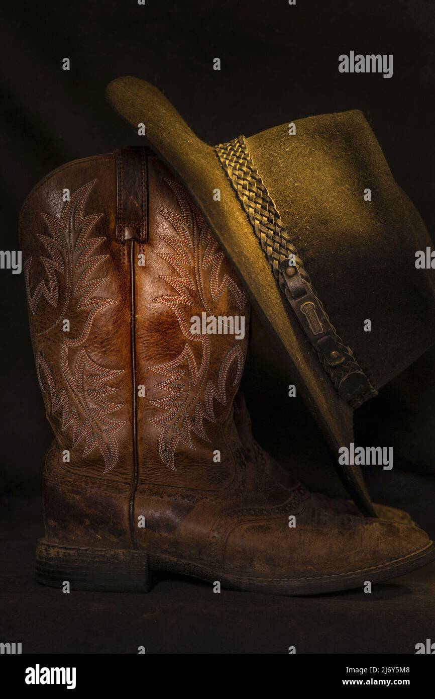 Cowboy hat and boots with intricate design etched into the leather. Stock Photo