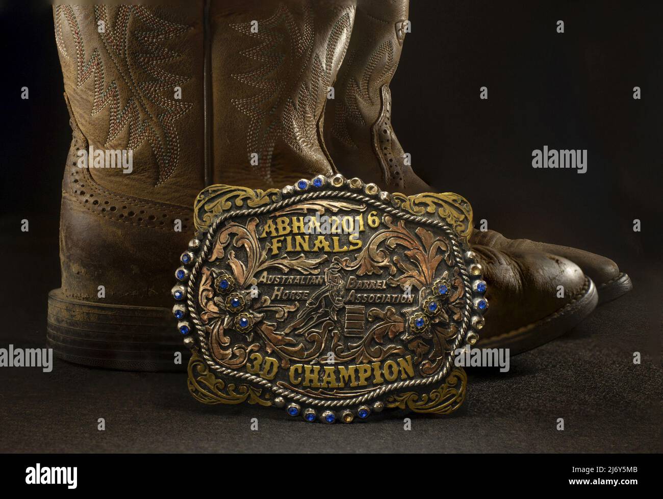 Riding boots and champion's buckle awarded the young winner of a national barrel-racing championship on a horse called Turbo at the ABHA 2016 finals. Stock Photo