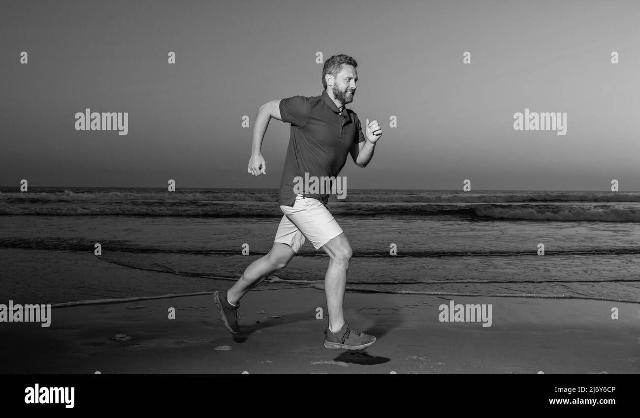 sportsman sprinter running on sunrise summer beach at ocean, athlete Stock Photo