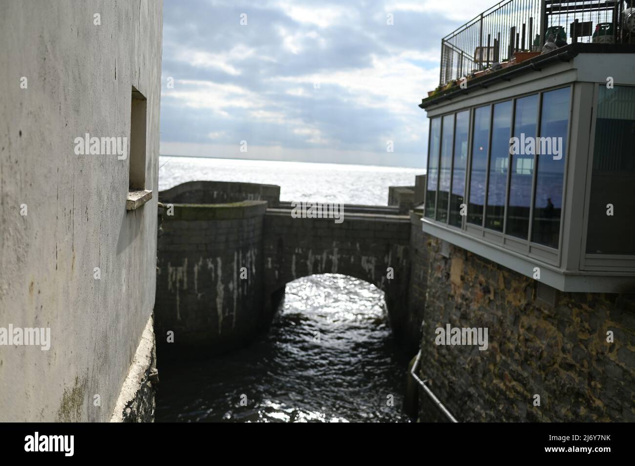 water way through Lyme Regis showing water front cafe windows Stock Photo