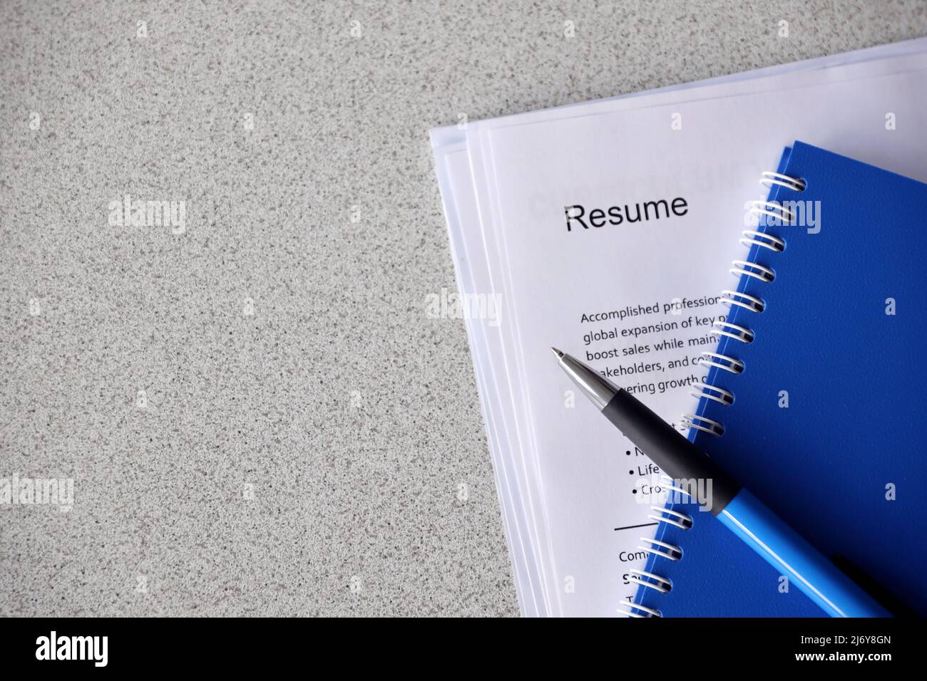 Top view of stack of office documents including resume and cv forms on the desk close to pen and notepad. Job seeking process. Hunting for workplace c Stock Photo