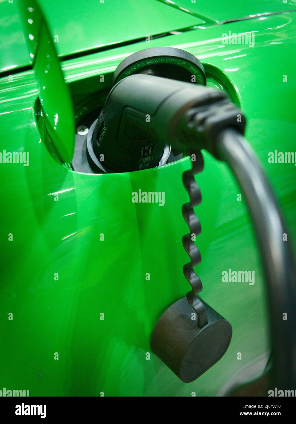 Close up of a Type 2 fast charging nozzle inserted into the charge socket on a green Porsche EV conversion electric vehicle Stock Photo