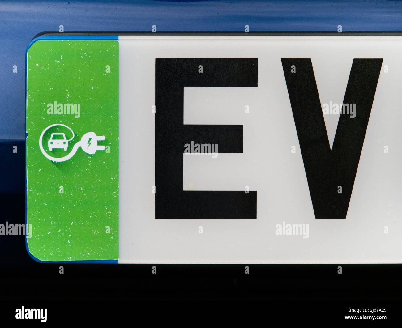 Green UK electric vehicle number plate showing the letters 'EV' Stock Photo