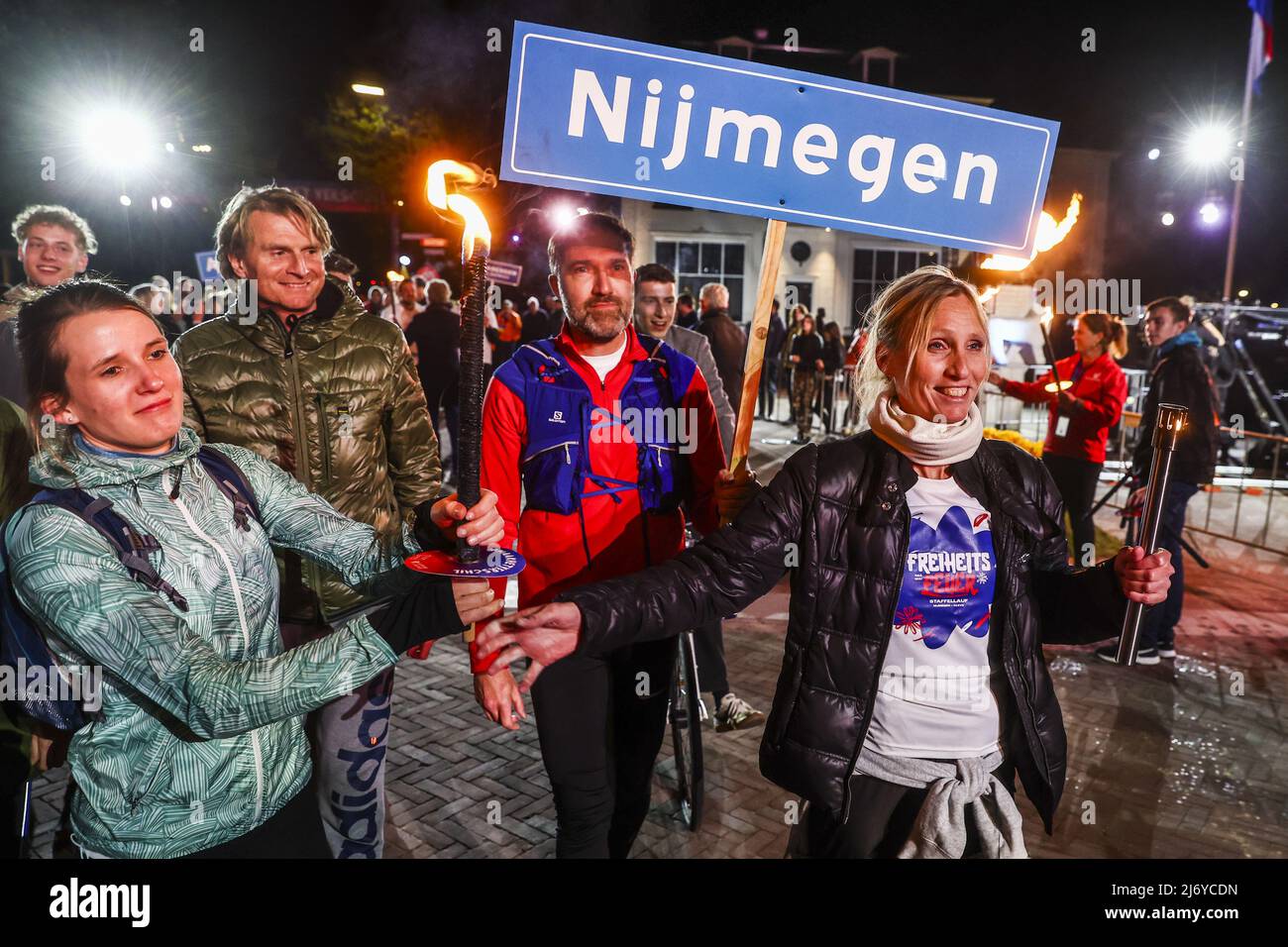 2022-05-05 00:50:17 WAGENINGEN - The runners from Nijmegen and the German neighboring municipality of Kleve leave with a torch after the liberation fire has been lit at Hotel De Wereld. The ceremony symbolizes the transition from commemorating war victims to celebrating freedom. The National Liberation Fire from Wageningen crosses the border for the first time, to Kleve, Germany, near Nijmegen. ANP VINCENT JANNINK netherlands out - belgium out Stock Photo