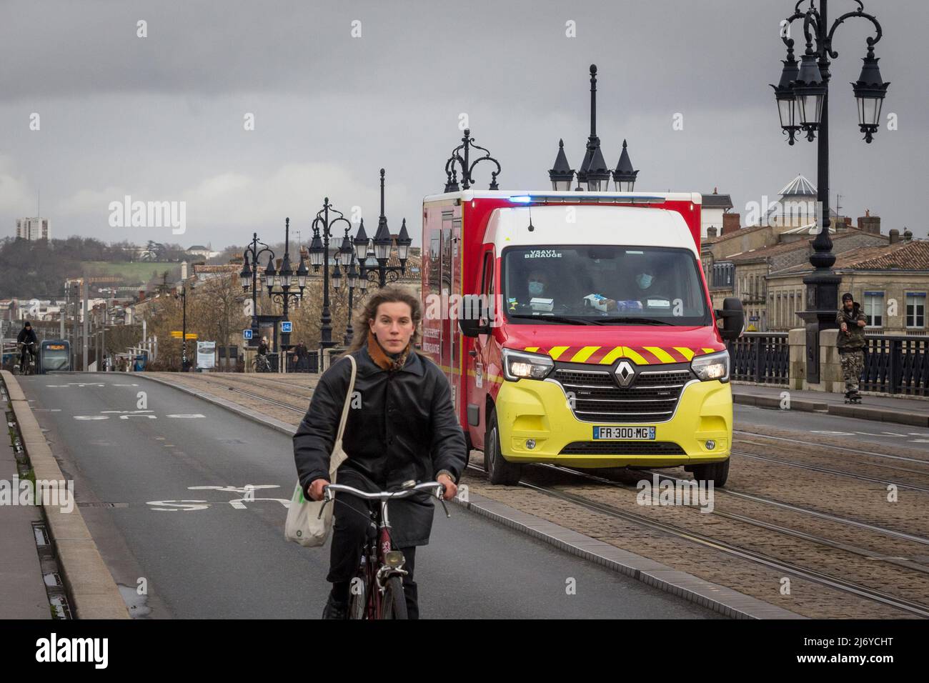 Picture of a cyclist passing in front of an emergency vehicle and first aid intervention van of the French pompiers, the administration of firemen and Stock Photo