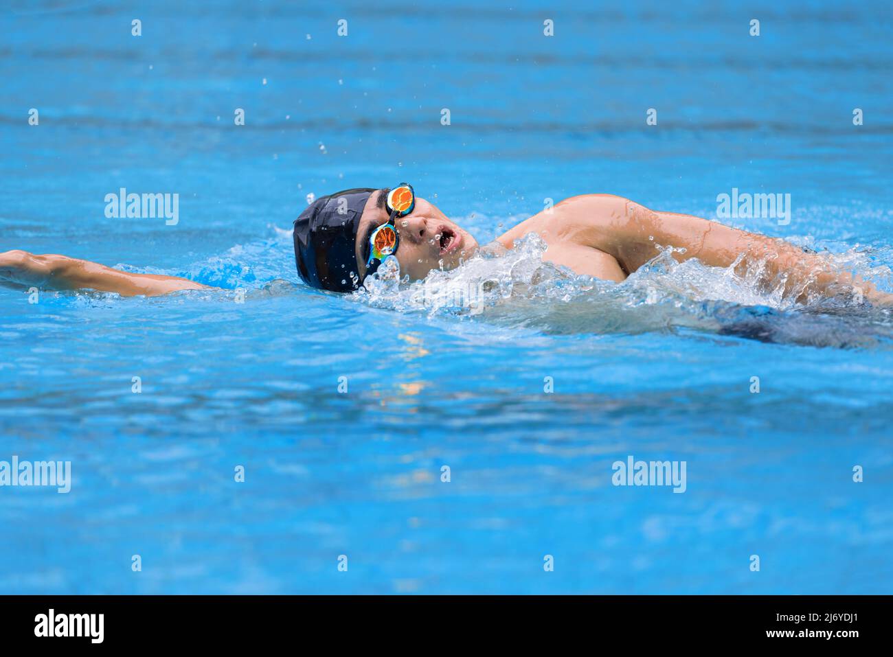 young swimmer in goggles exercising in swimming pool Stock Photo