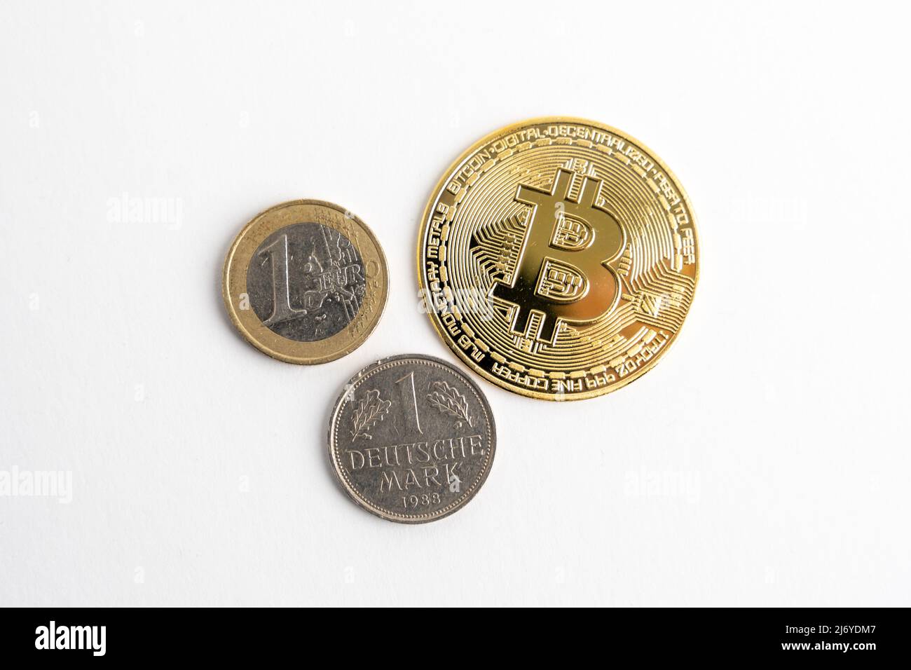 Bitcoin Euro and Deutsche Mark Coins  on a white background. German hard cash money evolution over time. Stock Photo