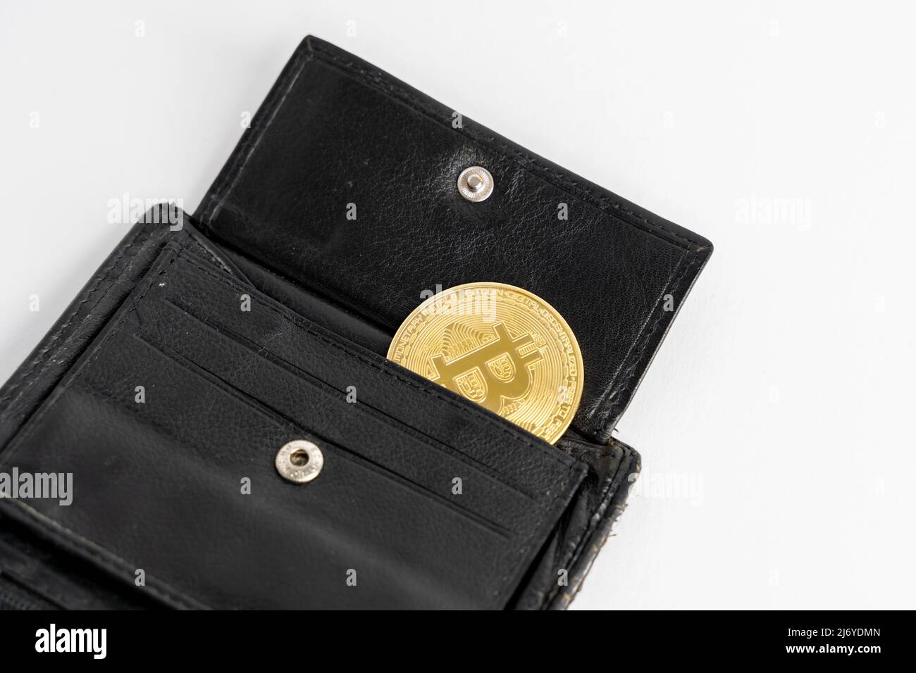 Bitcoin lying in a black leather wallet. Crypto currency BTC used as payment cash in everyday situations. Coin exchange of the future. Stock Photo