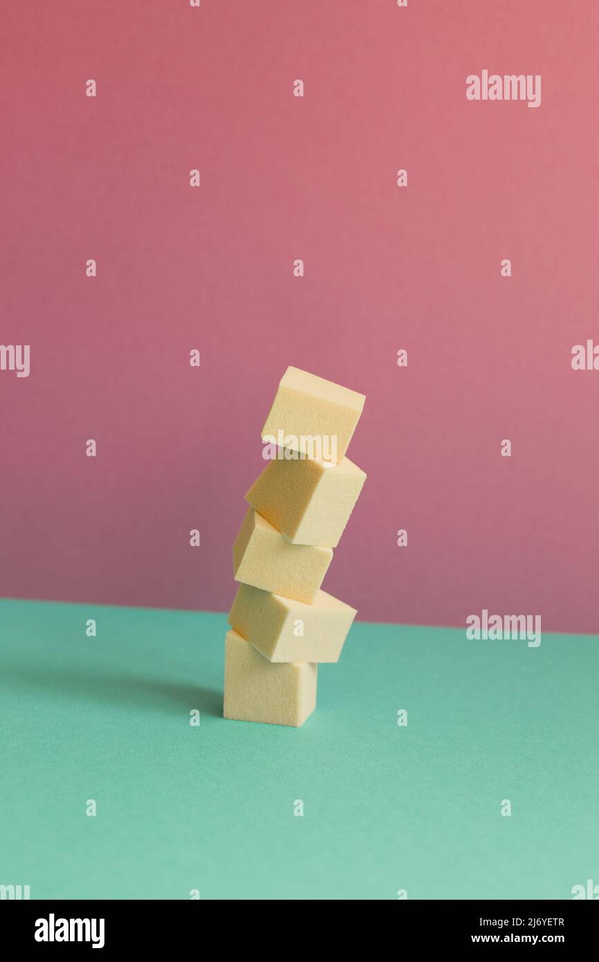 Stack of makeup sponge on mint green table. pink wall background Stock Photo