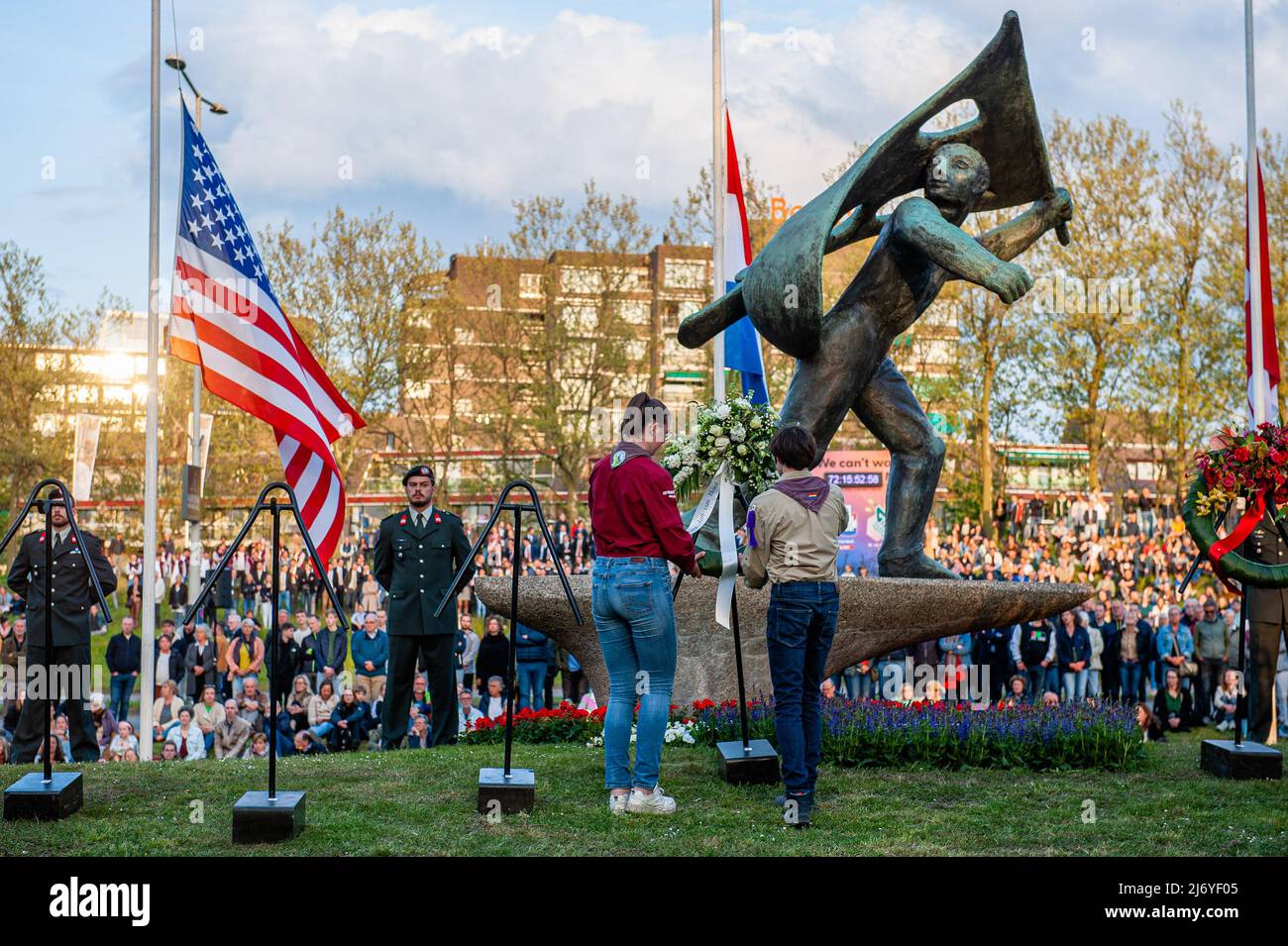 Boy scouts are seen leaving a wreath of flowers at the monument. On