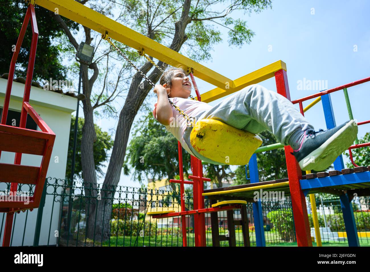 happy little hispanic girl child having fun to playing in the park in summer time with smile and laughing healthy, Adorable girl having fun on a swing on summer. happy vacation lifestyle concept Stock Photo