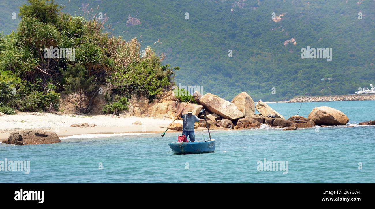 A local man rowing his small boat near the northern shore of Peng Chau island, Hong Kong. Stock Photo