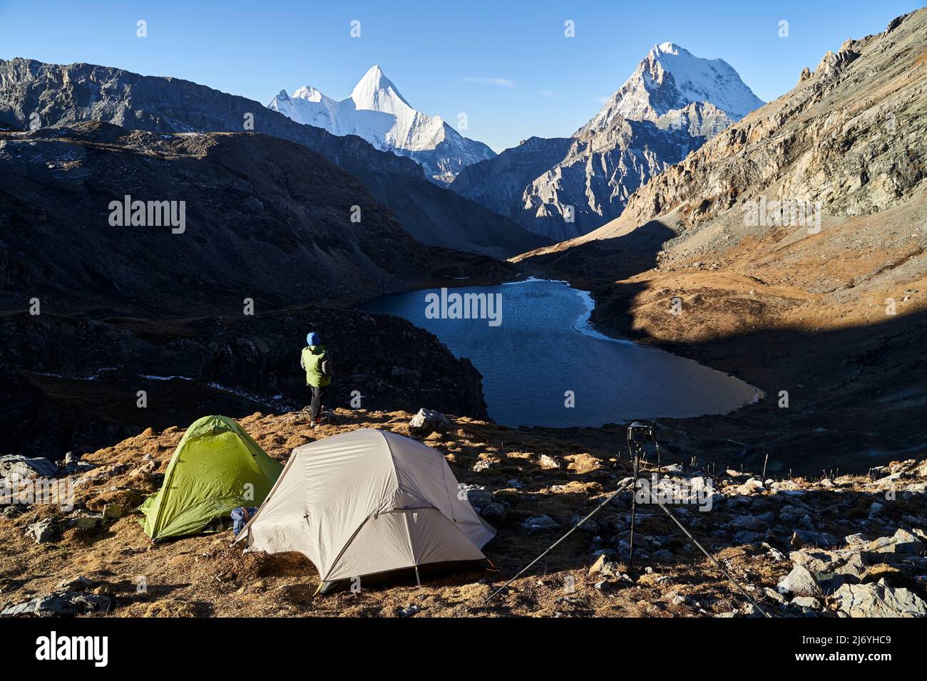 rear view of asian woman female photographer looking at view at camp ground in yading national park, daocheng county, sichuan province, china Stock Photo