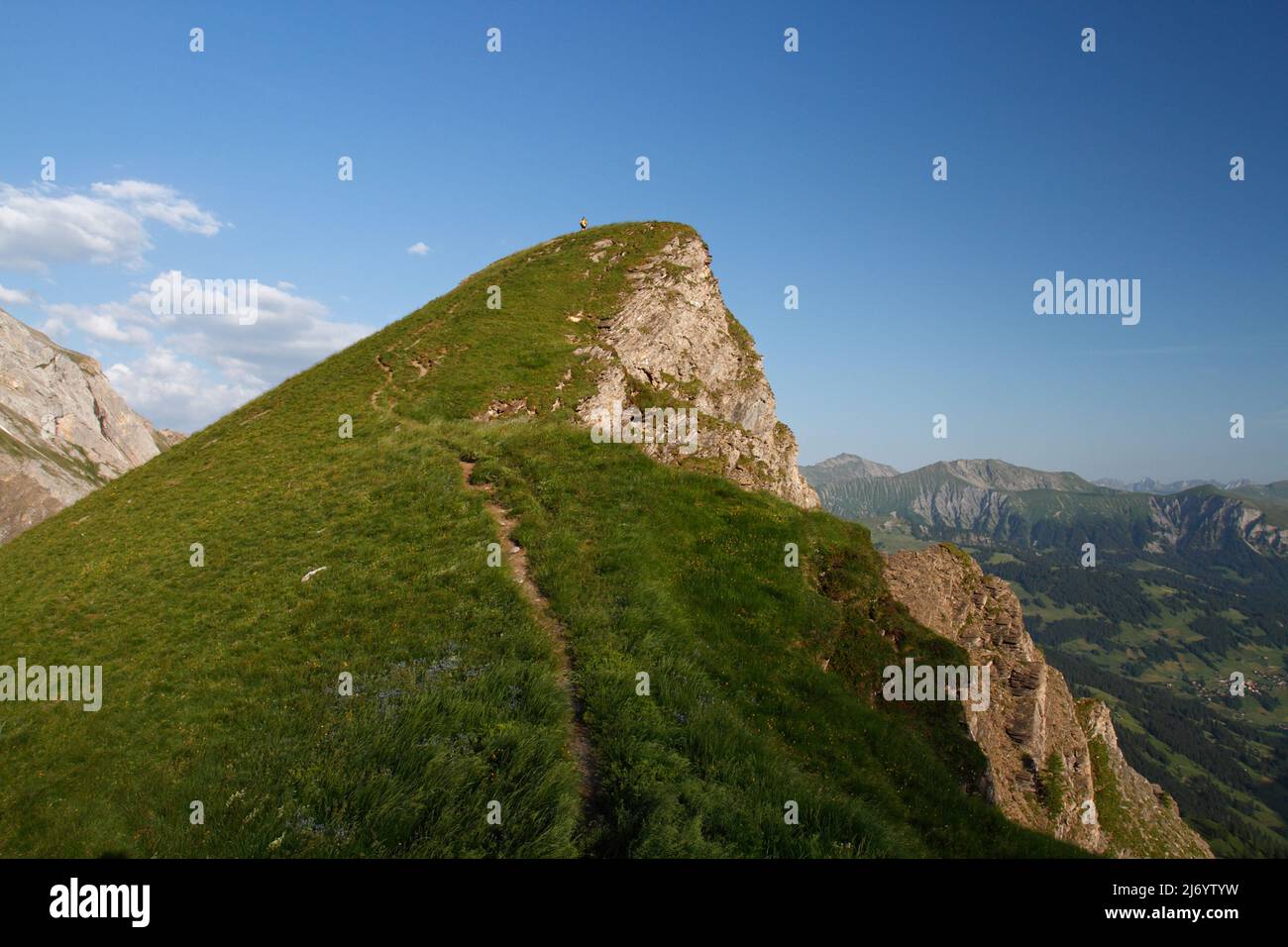 Female hiker far away on the top of a mountain in Switzerland Stock Photo