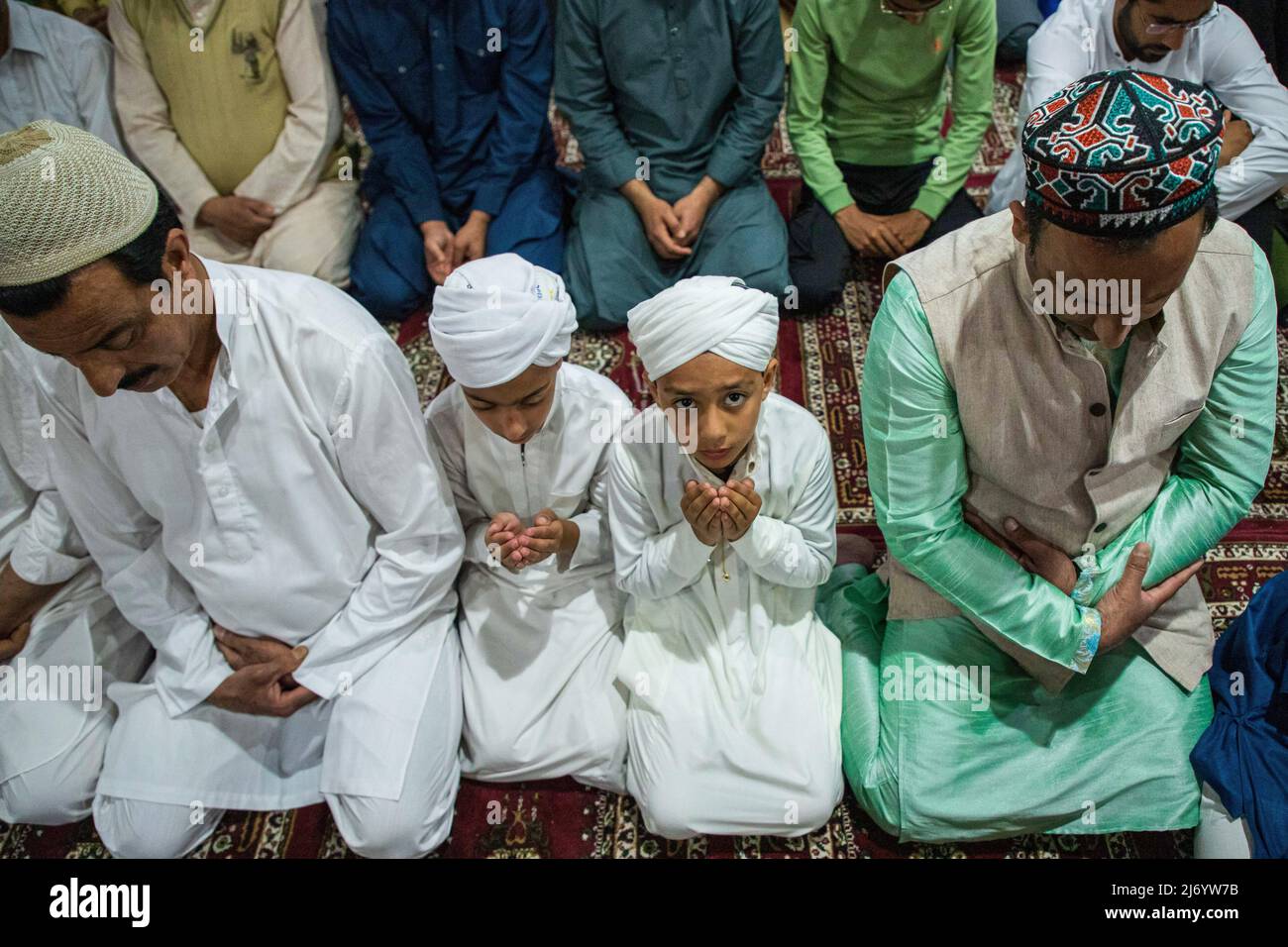 Kashmiri Muslim boys praying inside a local mosque during EidalFitr prayers in Srinagar. Eid