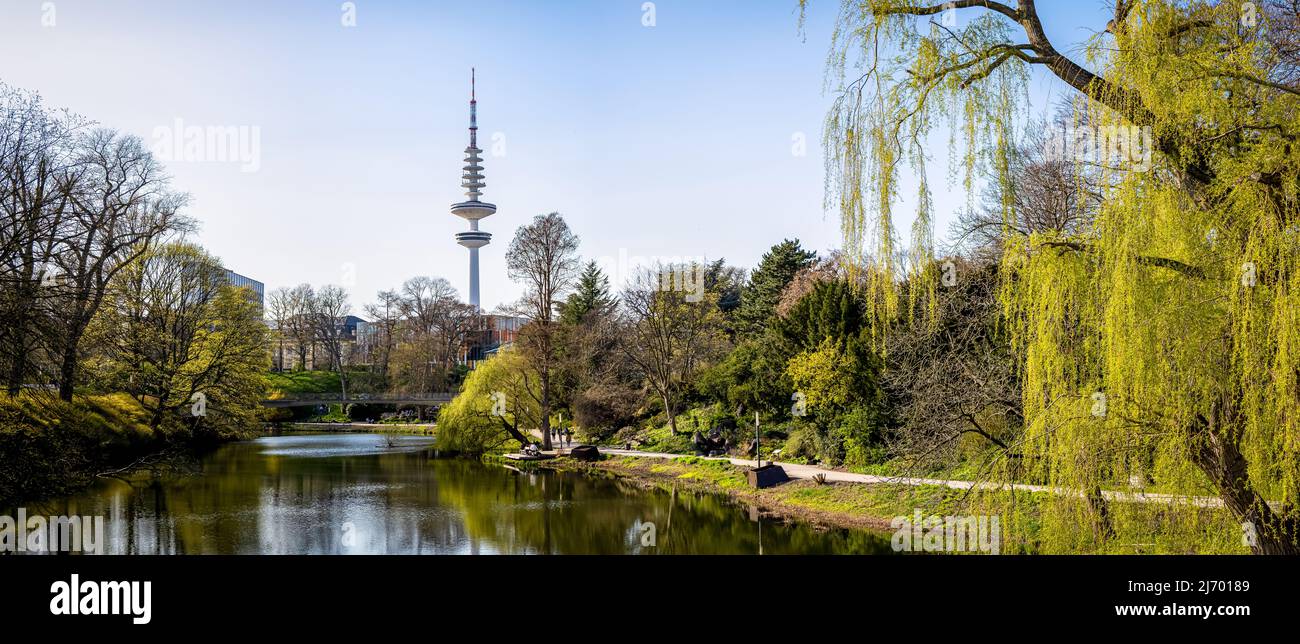 horizontal wide angle panorama view from old main entrance of planten un blomen garden in the wallgraben to the famous heinrich-hertz television tower Stock Photo