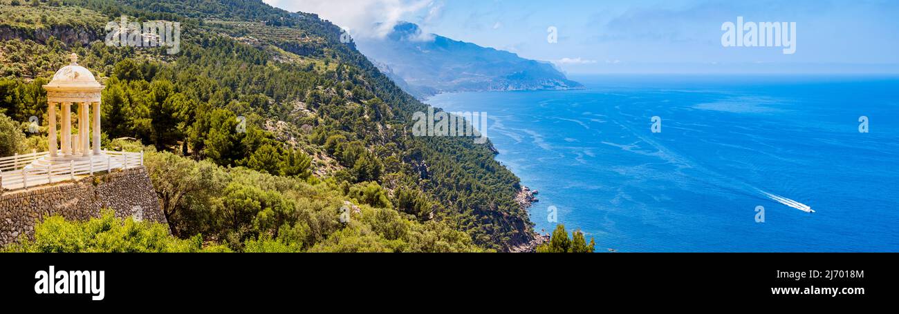 Temple of son marroig sits enthroned on the left side of the coastline of deia above the mediterranean sea in a dreamlike environment, ultra wide shot Stock Photo