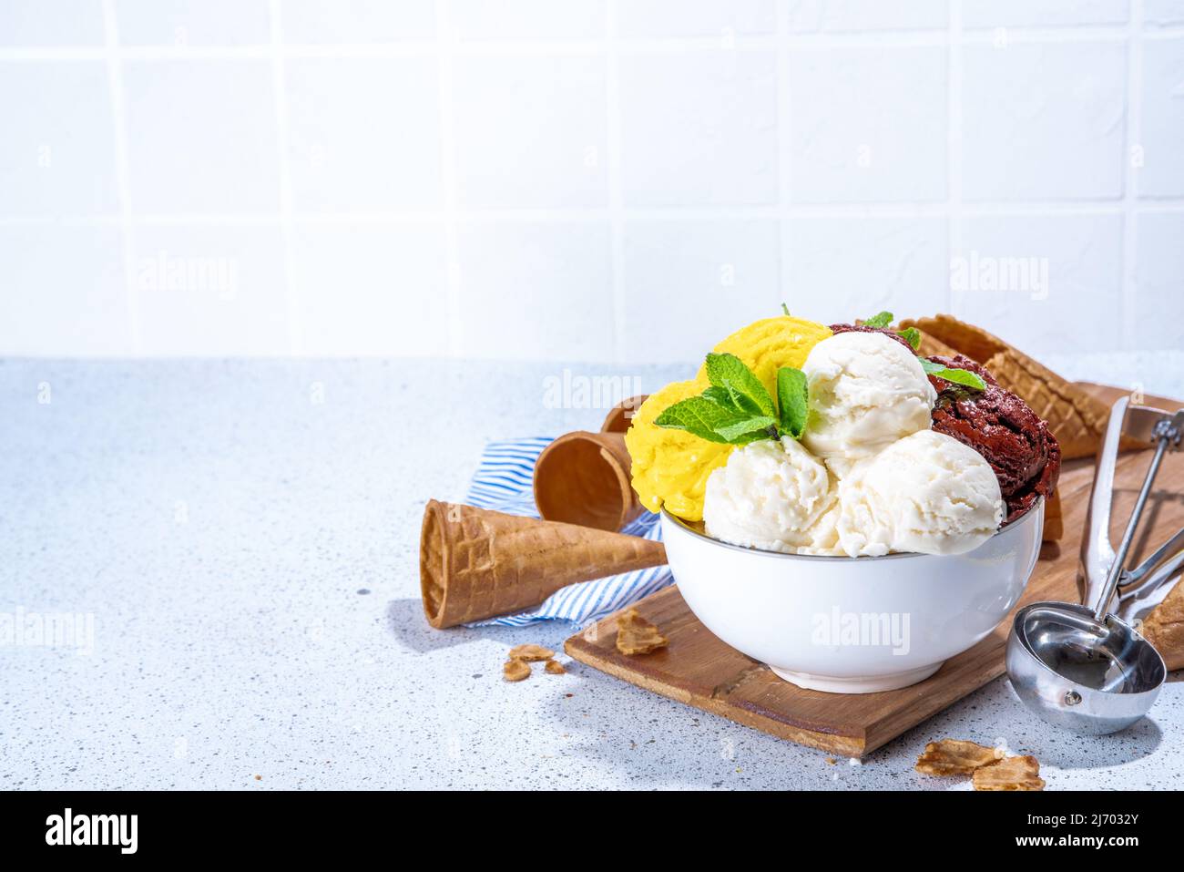 Lemon, chocolate and vanilla ice cream balls. Big bowl with ice cream  scoops, on white kitchen table background with waffle cones, copy space  Stock Photo - Alamy