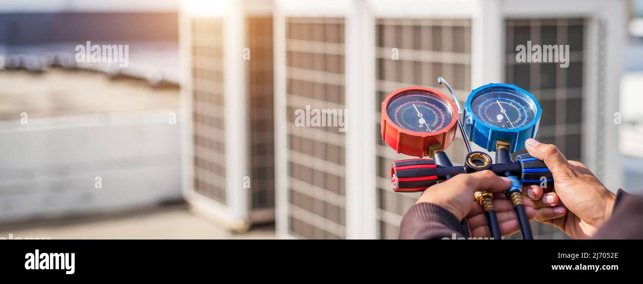 Technician checking air conditioning operation, detecting refrigerant