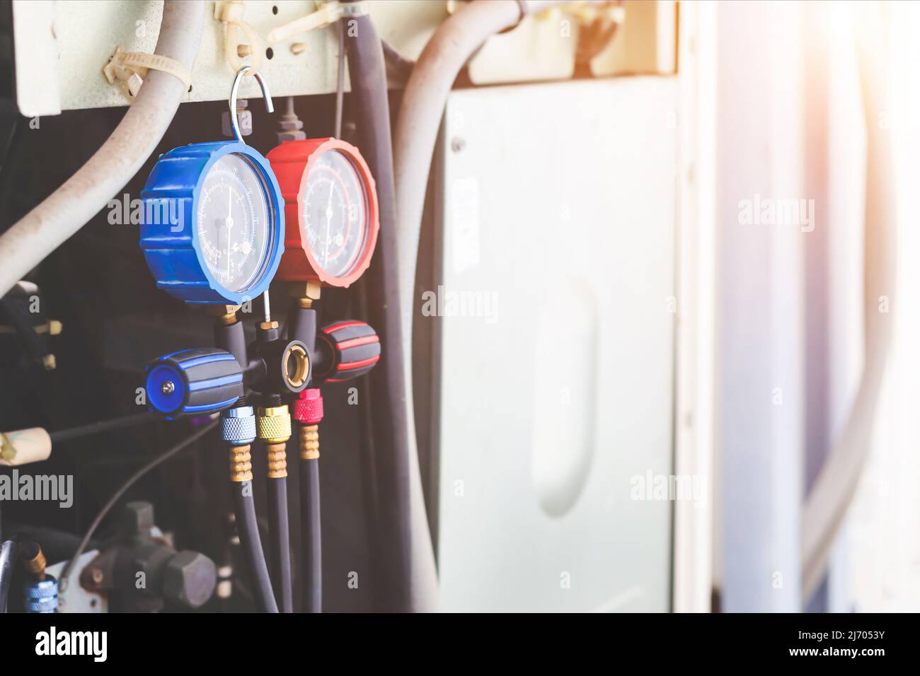 Technician checking air conditioning operation, detecting refrigerant