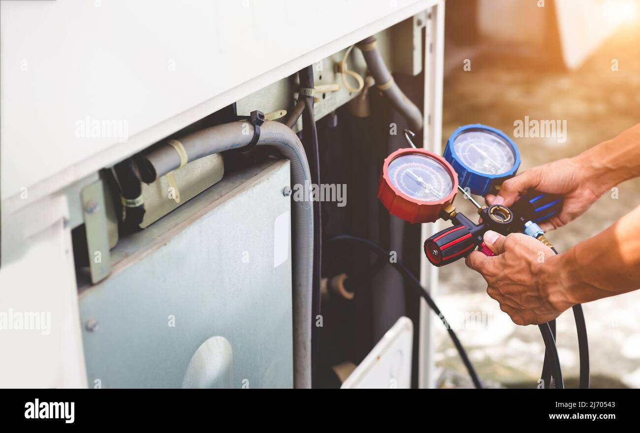 Technician checking air conditioning operation, detecting refrigerant leaks Stock Photo Alamy