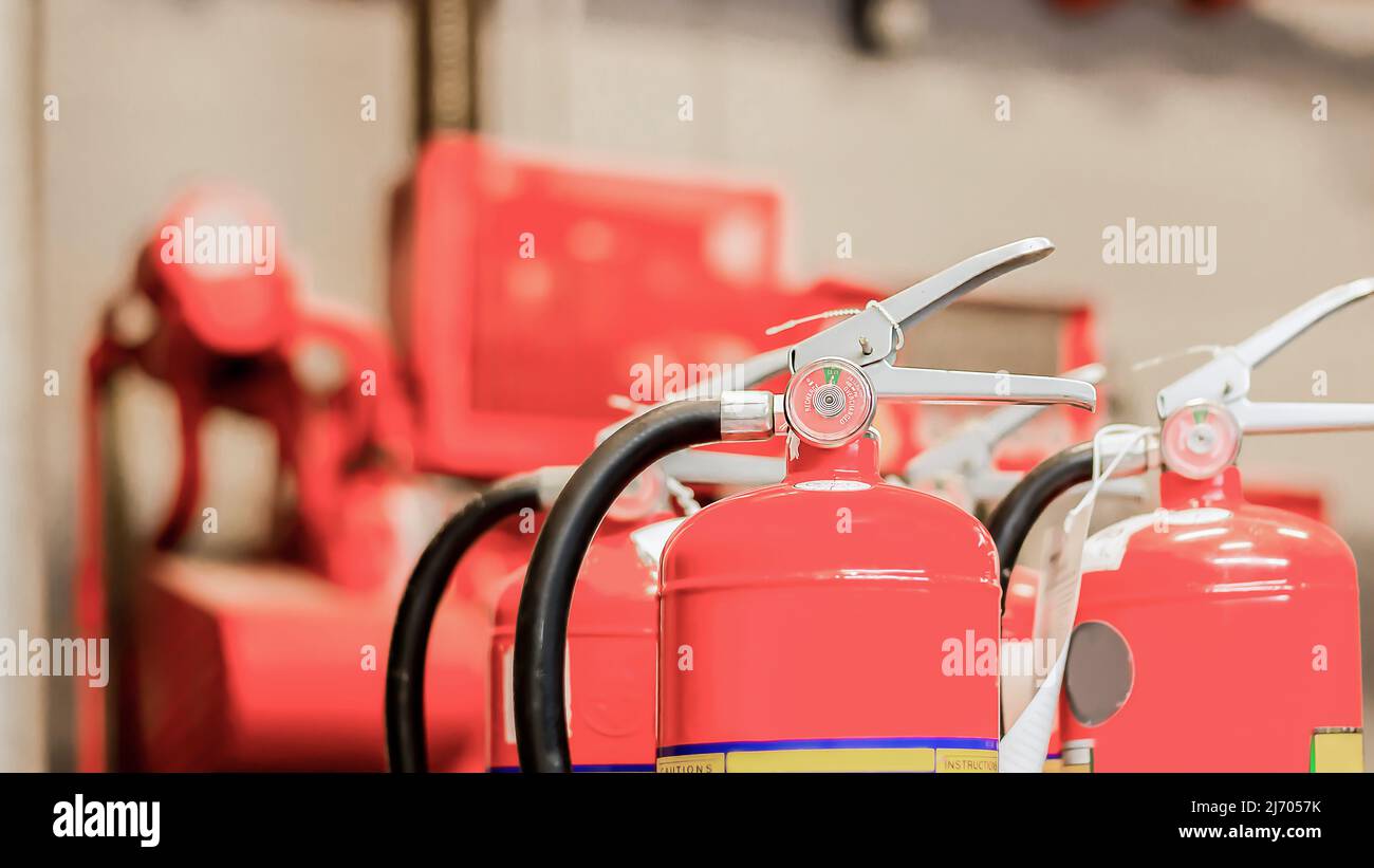 The red fire extinguisher is ready for use in case of an indoor fire emergency. Stock Photo