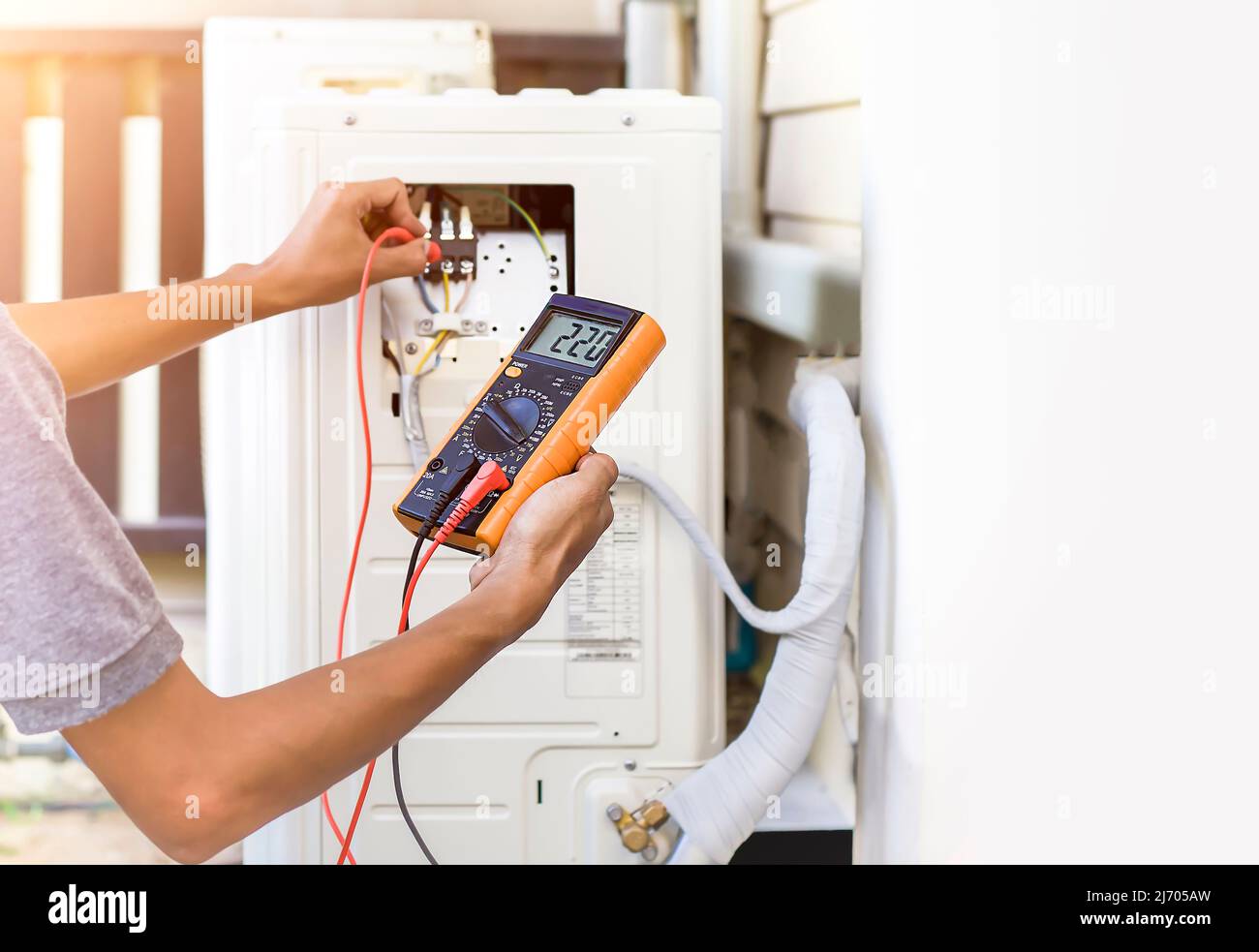 Air conditioner repairman using electricity meter to check air