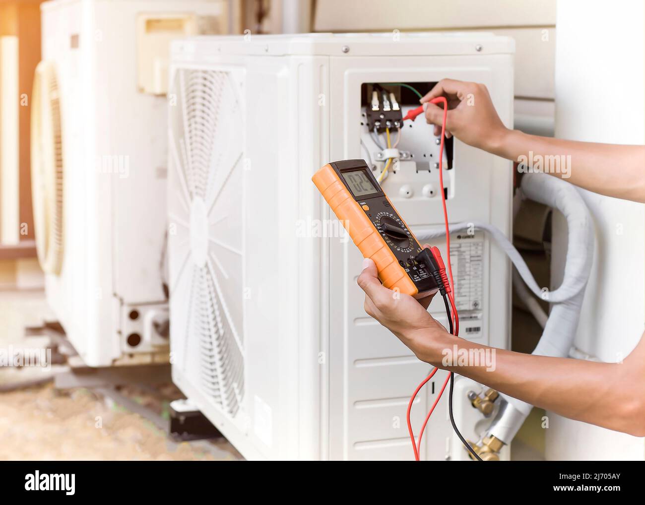 Technician checking air conditioning operation, detecting refrigerant