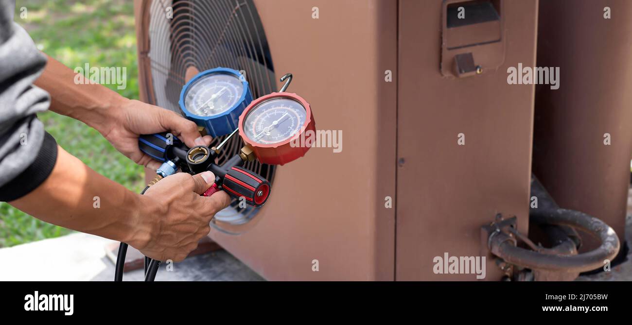 Technician checking air conditioning operation, detecting refrigerant
