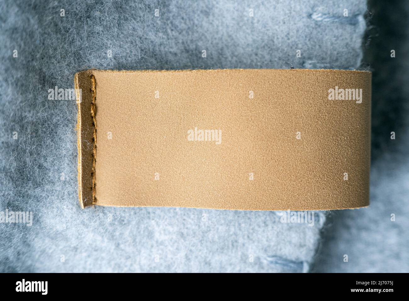 Leather blank label, brown patch on a blanket as mockup, space for text Stock Photo