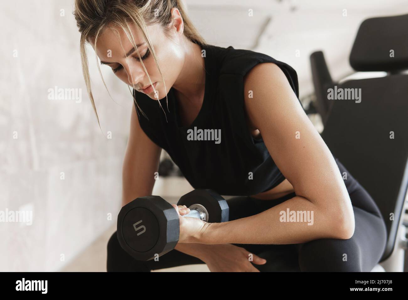 athletic-woman-doing-bicep-curl-exercise-with-a-dumbbells-in-the-gym