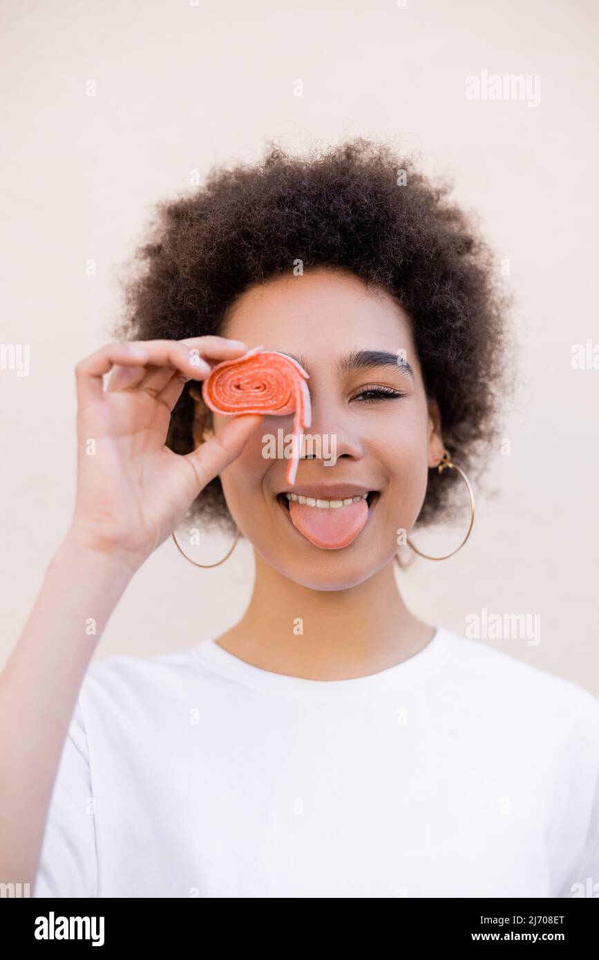 happy african american young woman covering eye with jelly bubble tape