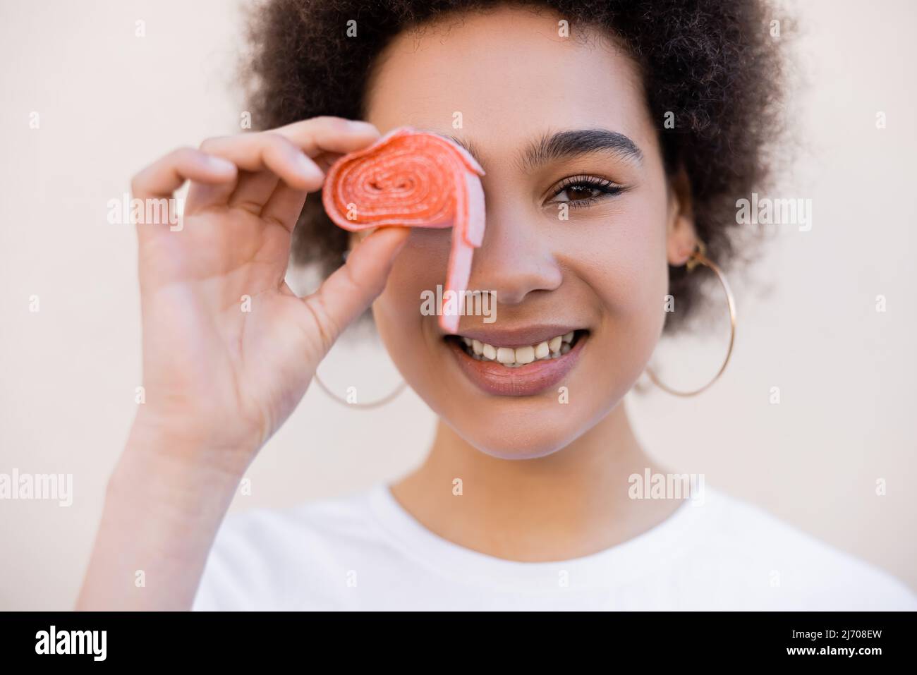 happy african american young woman covering eye with jelly bubble tape