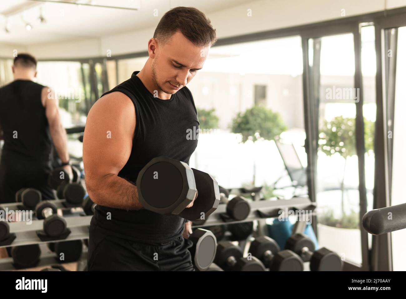 Bodybuilder Training Man exercising with a dumbbells during his bodybuilding workout in the ...
