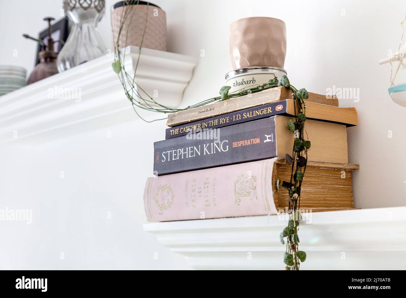 Floating shelves with home doecroation and stacked books, powder pink and white colour palette Stock Photo