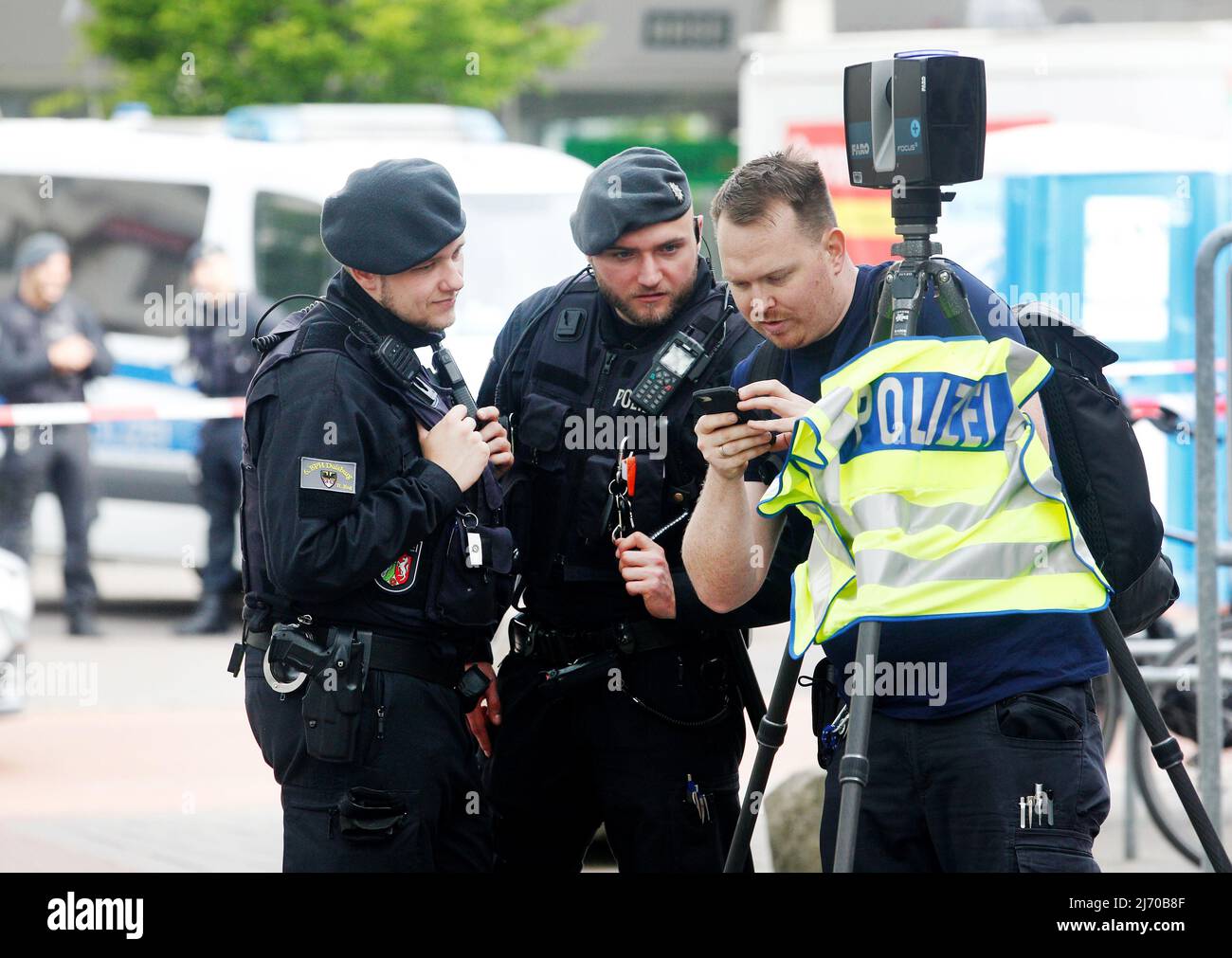 05 May 2022, North Rhine-Westphalia, Duisburg: Police officers examine the scene on the market square with a camera. Four people were injured in open street shooting on Wednesday (04.05.2022). 15 people were temporarily taken into custody, police and prosecutors announced on Thursday. A homicide squad has taken over the investigation. Photo: Roland Weihrauch/dpa Stock Photo