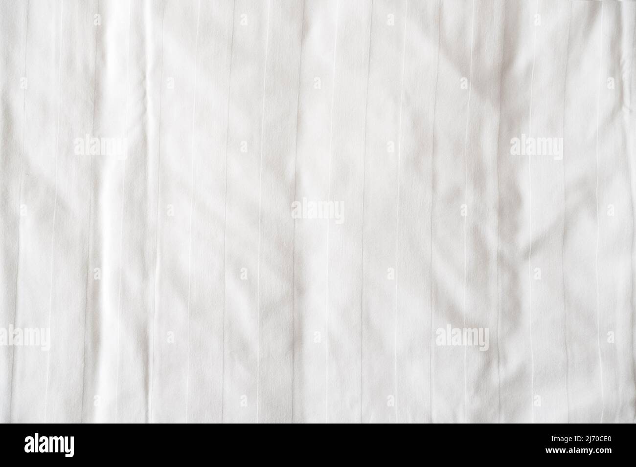 White bed linen, sheet as texture or background, crumpled blank bedclothes top view Stock Photo