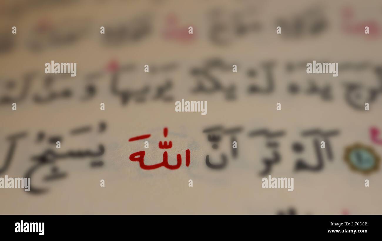 Arabic Allah text in open quran page, macro shot of Islamic God, quran idea and muslim concept, sitting view, selective focus, close up Stock Photo