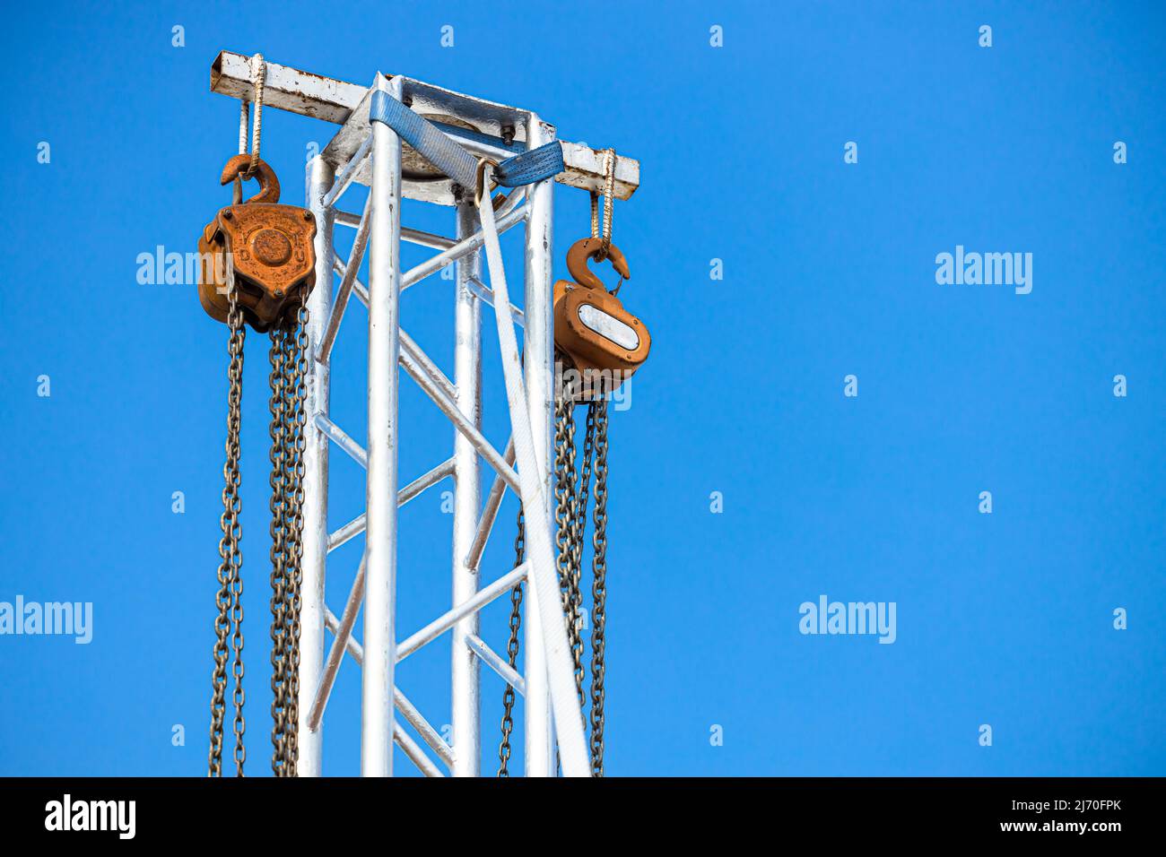 manual hoist pully wheel with metal chain at tower for lift heavy stage light structure in concert exhibition area Stock Photo