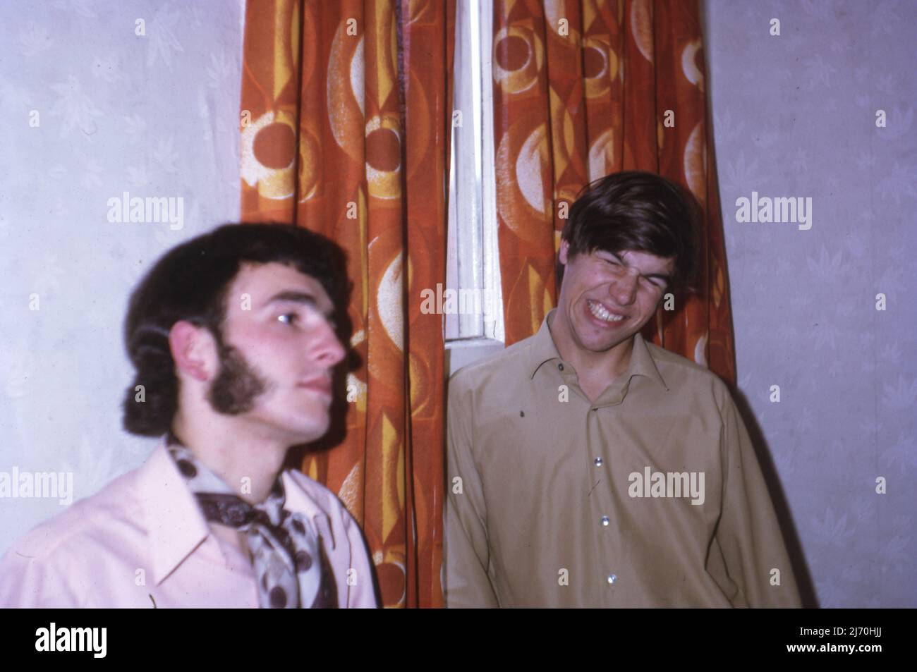Party goers infront of gaudi curtains. Note the cravate and sideburns . July 1968.  Photo by Tony Henshaw Archive Stock Photo