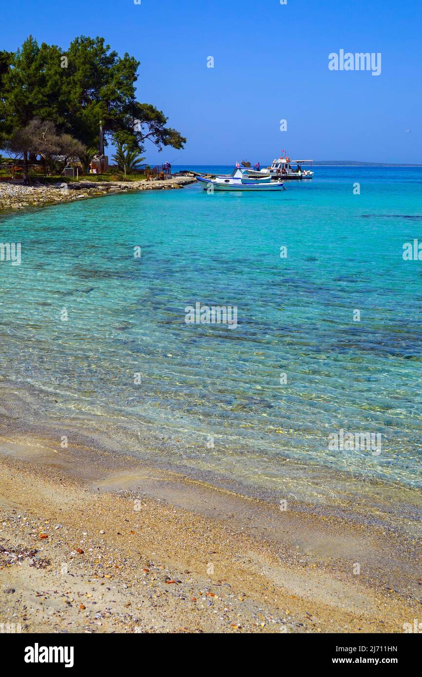 Fishing boats, Blue water at Çamkoru Sitesi Plajı beach near Akbuk, Turkey Stock Photo