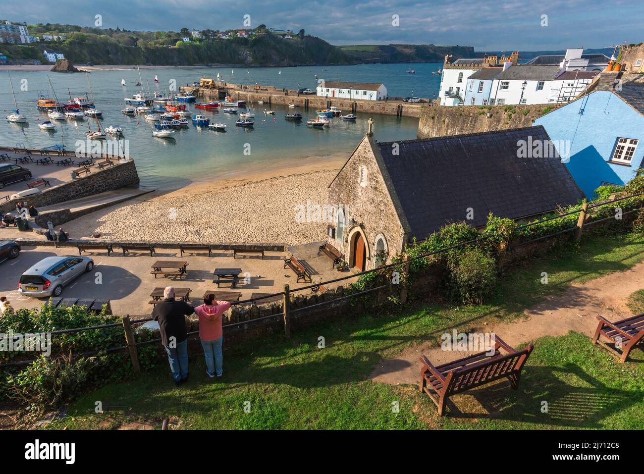 Wales travel, rear view of a mature couple looking down on the small sandy beach in Tenby harbour, Pembrokeshire coast, Wales, UK Stock Photo