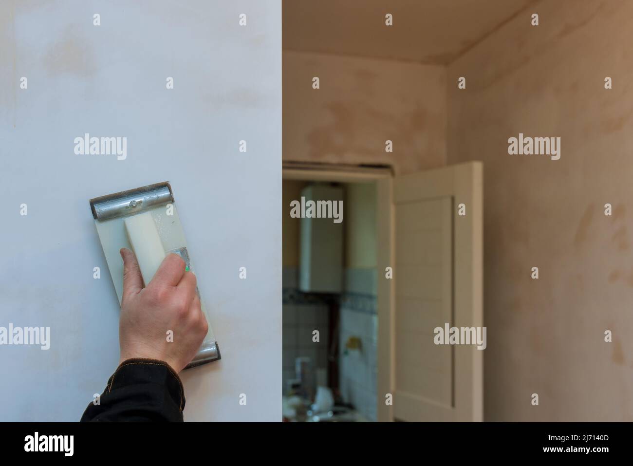 Contractor using sand trowel sanding the drywall ceiling during room renovation Stock Photo Alamy