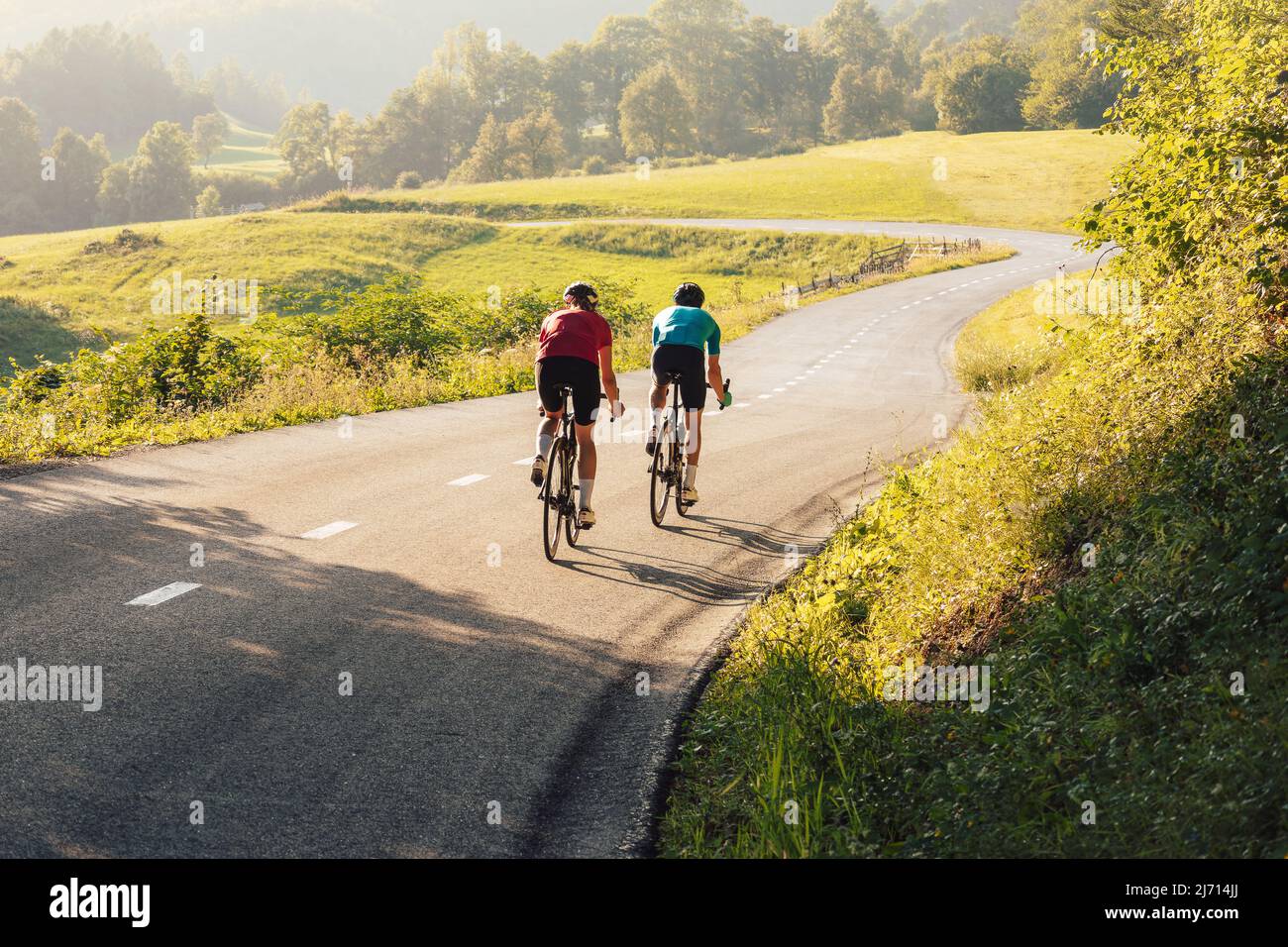 Two road cyclists, male and female during training at beautiful nature