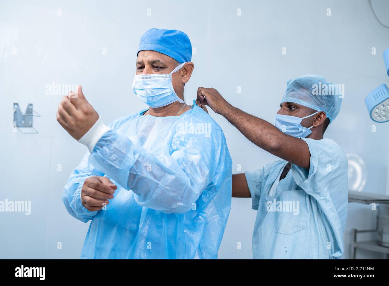 nurse helping Surgeon to wear gown at operation theatre for surgery